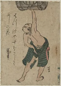 Sake: A man lifting a sake barrel