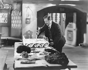 Indulgence: Man lighting candles on cake