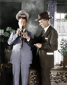 Thirtysomething: Man lighting a long pipe while his hat is lifting