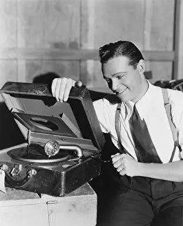 Portability: Man listening to record player