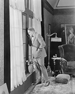 Insecure: Man in a living room looking out the window