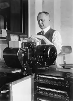 Computation: Man loading punch cards into a tabulating ?