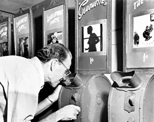 Noticing: Man looking into a nickelodeon film machine