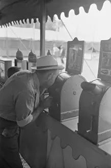 Donaldsonville: Man looking through penny peep show, state fair, Donaldsonvi