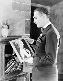 Intent: Man looking at picture of woman