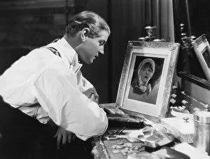 Pining: Man looking at portrait of woman