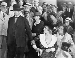 Hostility: Man looking at his wife in anger while a group of