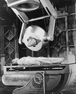 Labs: Man lying below huge machine