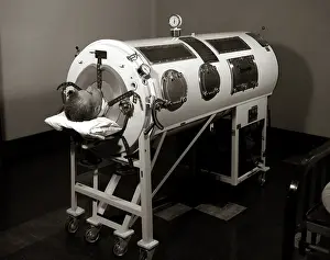 Poliomyelitis: Man lying in iron lung negative pressure ventilator