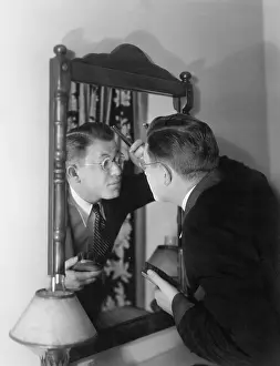 Focused: Man at mirror combing hair