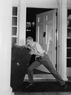 Maneuvering: Man moving heavy trunk