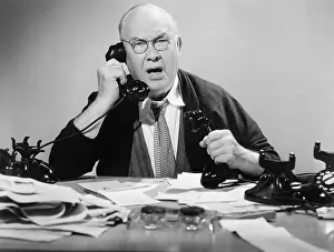 Scream: Man on multiple telephones looking angry