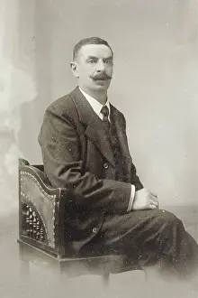Man with a mustache in a studio chair