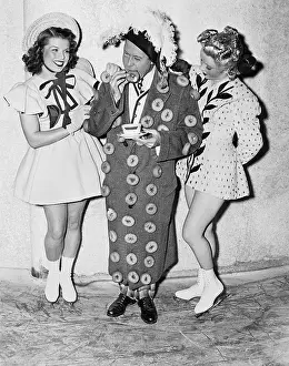 Wink: Man in an outfit made of donuts standing between