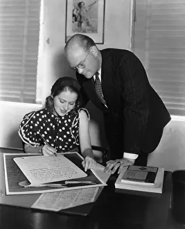Endorsement: Man overseeing woman signing document