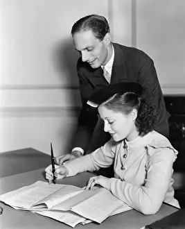 Supervise: Man overseeing young womans work