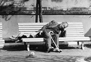 Napping: Man and pet dog asleep on bench