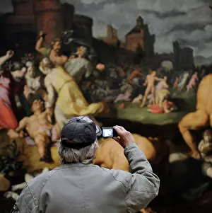 Photographing: Man photographing a painting