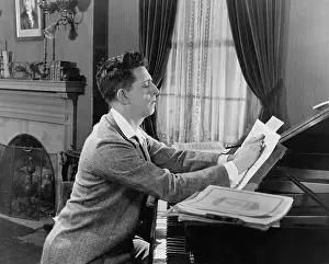 Compositions: Man at piano writing on sheet music