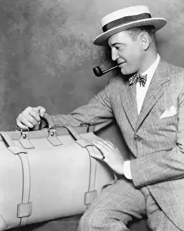 Getaway: Man with a pipe looking at his luggage