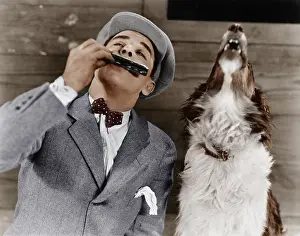 Collaborate: Man playing harmonica with howling dog