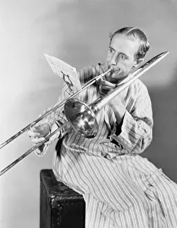 Pajamas: Man playing trombone in nightgown