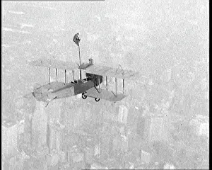 Squatting: Man Pole Squatting On Top of a Flying Biplane