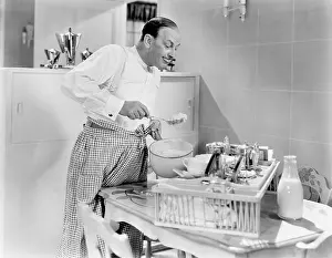Foodstuff: Man preparing food in a kitchen