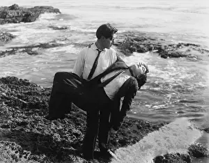 Demise: Man pulling a dead man out of the ocean