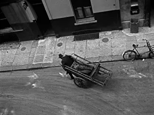 Grating: A man pulls a barrow in Marshall Street, London