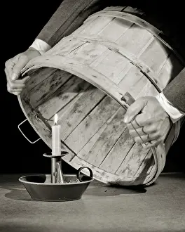 Bushel: Man Putting a Bushel Basket Over a Lit Candle Do