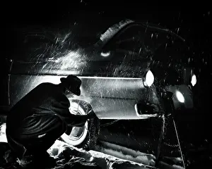 Slush: Man Putting Chains on Rear Tires at Night