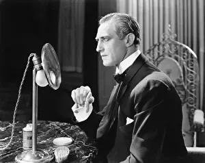 Thespians: Man putting powder onto his face in front of a mirror