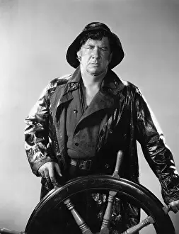Raincoats: Man in raincoat steering boat