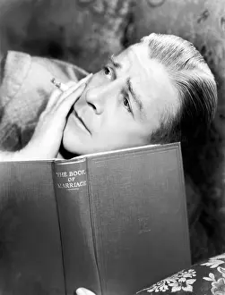 Lamenting: Man reading a book with a cigarette in a hand