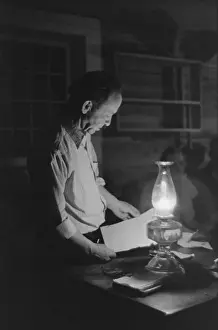 Kerosene: Man reading by the light of a kerosene lantern. ?