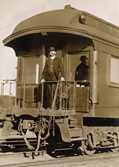 Sheltered: Man at the rear of a railway train, USA