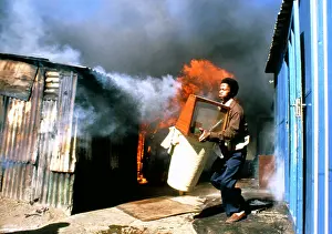 Armful: A man runs outside clutching an armful of possessions