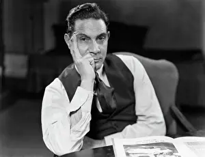 Man Seated Elbows On Table Face Leaning On Hand Serious
