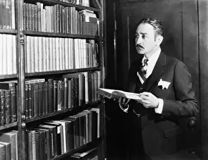 Mustaches: Man selecting books from bookshelf in a library