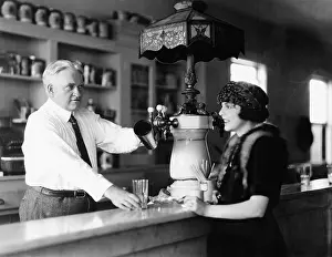 Establishments: Man serving beverage to woman at counter