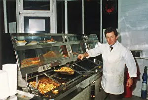 Takeaway: Man serving in fish and chip shop, Cornwall