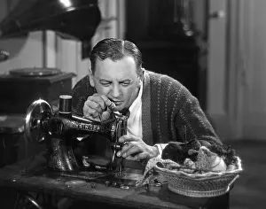 Housekeeping: Man at a sewing machine, 1930s