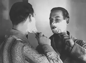 Shave: Man shaving in front of a mirror