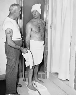 Bathrooms: One man about to shower and one attendant in a bathroom