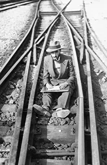Placidly: A Man sits on the railway tracks
