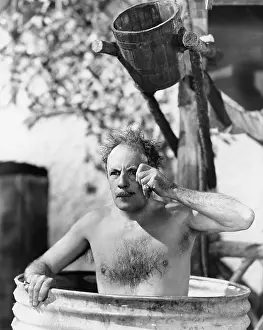 Seriousness: Man sitting in a barrel taking a bath and looking