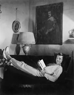 Mustaches: Man sitting on a couch reading a book