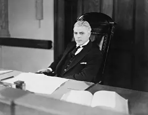 Brood: Serious man sitting at desk