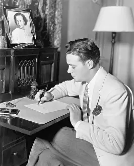 Ponder: Man sitting at his desk writing a letter with a